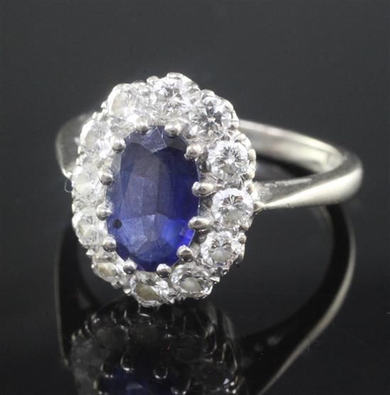 An 18ct white gold, sapphire and diamond oval cluster ring, size K.